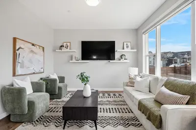 a living room with a couch and chairs and a tv at Herron Rise Luxury 4 Bedroom Main Floor in Calgary