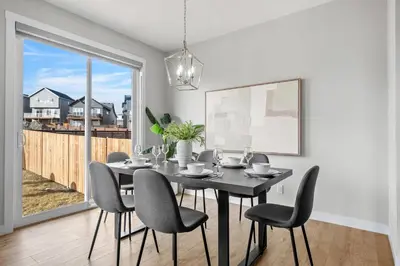 a dining room with a table and chairs and a large window at Herron Rise Luxury 4 Bedroom Main Floor in Calgary