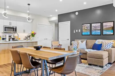 a kitchen and living room with a wooden table and chairs at Tranquil 2BR Golden Oasis BBQ, Balcony, MTN Views in Golden