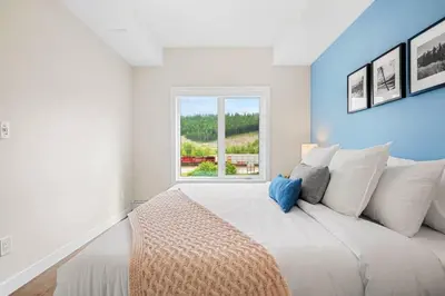 a bedroom with a large white bed with a window at Brand New 2BR Oasis Mins to DT with AC Balcony and BBQ in Golden