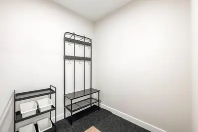 a bathroom with white walls and two shelves with towels at Brand New 2BR Oasis Mins to DT with AC Balcony and BBQ in Golden