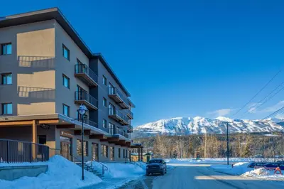 a building on a street with snowy mountains in the background at Modern 2BR in Golden w/ Stunning MTN Views! in Golden