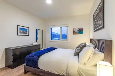 a bedroom with a bed and a desk and two windows at Modern 2BR in Golden w/ Stunning MTN Views! in Golden