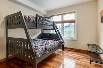 a bedroom with two bunk beds and a window at Cozy 2 BR Condo plus Gym with Stunning Mountain View in Canmore
