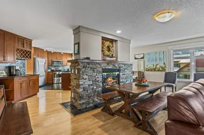 a kitchen and a living room with a fireplace at Mountain View Retreat Elegant 3BR condo with Gym in Canmore