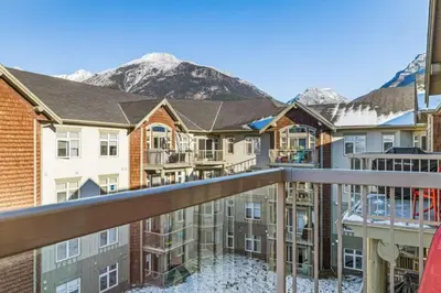 a view from the balcony of a apartment building with mountains in the background at Mountain View Retreat Elegant 3BR condo with Gym in Canmore