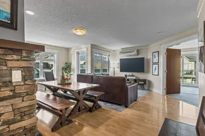 a living room with a table and a stone wall at Mountain View Retreat Elegant 3BR condo with Gym in Canmore