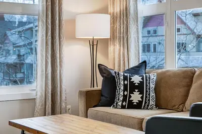 a living room with a couch and a table at Charming 2BR Condo with Spectacular Mountain Views in Canmore