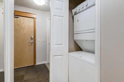 a kitchen with a washer and dryer next to a door at Charming 2BR Condo with Spectacular Mountain Views in Canmore