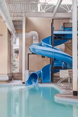 a water slide in a building with a swimming pool at Rockies Getaway Condo With Mountain View in Canmore