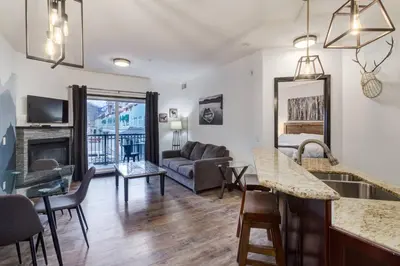 a kitchen and living room with a couch and a table at Renovated Haven in Rockies with Hot Tub and Pool in Canmore