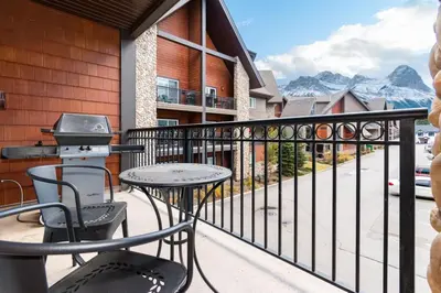 a balcony with a grill and a table and chairs at Renovated Haven in Rockies with Hot Tub and Pool in Canmore