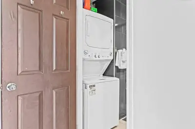 a kitchen with a washer and dryer next to a door at 2BR Bow Valley Retreat with BBQ Near Parks and Banff in Canmore