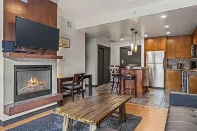 a living room with a fireplace and a table at Relaxing 1BR Getaway Hot tub plus Amazing Mtn Views in Canmore