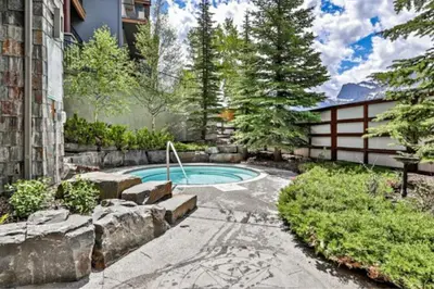 a swimming pool in the backyard of a house at Cozy Rocky Mountain Studio with Hot tub and Gym in Canmore