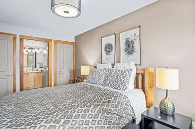 a bedroom with a bed and a lamp on a table at Peaceful 2BR Retreat with MTN Views Close to Banff in Canmore