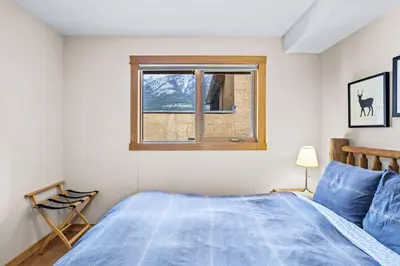 a bedroom with a bed and a window at Peaceful 2BR Retreat with MTN Views Close to Banff in Canmore