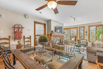 a living room with a ceiling fan and tables and chairs at Rustic Creekside Retreat 2BR with Stunning View in Canmore