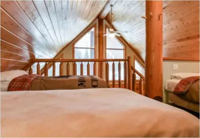 a bedroom with two beds and a large window at Charming Rustic Cabin Perfect for Groups in Golden