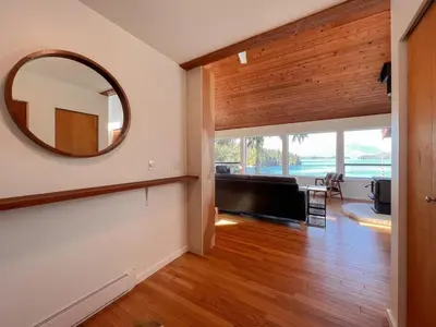 a living room with a mirror on the wall at Marielles Lookout - Your Oceanfront Escape Framed by Forest & Waves in Tofino