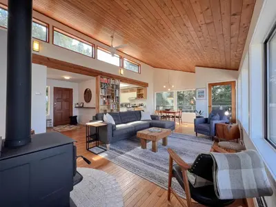 a living room with a couch and a fireplace at Marielles Lookout - Your Oceanfront Escape Framed by Forest & Waves in Tofino