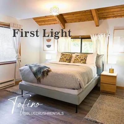 a bedroom with a first light sign above a bed at First Light - Vintage waterfront with hot tub - One Bedroom in Tofino