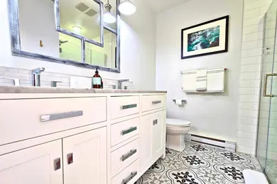 a white bathroom with a sink and a toilet at Cedar and Salt in Tofino