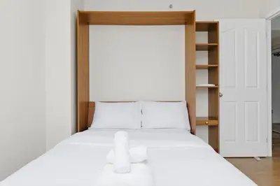a white bed with a teddy bear sitting on it at Downtown Skyline Suite with Pool & Sauna in Vancouver