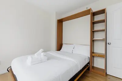 a bedroom with a white bed and a mirror at Downtown Skyline Suite with Pool & Sauna in Vancouver
