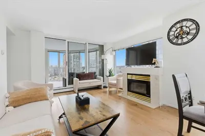 a living room with a fireplace and a tv at Downtown Skyline Suite with Pool & Sauna in Vancouver