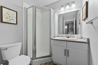 a bathroom with a shower and a toilet and a sink at The Cabin Sleep in Edmonton