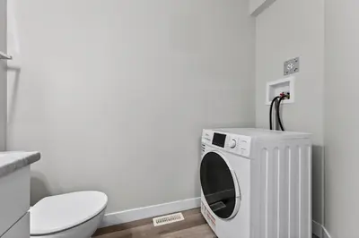 a washing machine in a bathroom next to a toilet at The Cabin Sleep in Edmonton