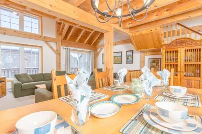 a dining room and living room with a table and chairs at Alpine Timbers 2 Luxury Chalet with Hot Tub in Big White