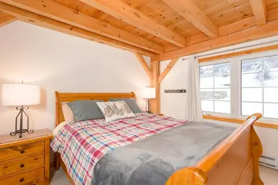 a bedroom with a bed and a wooden ceiling at Alpine Timbers 2 Luxury Chalet with Hot Tub in Big White
