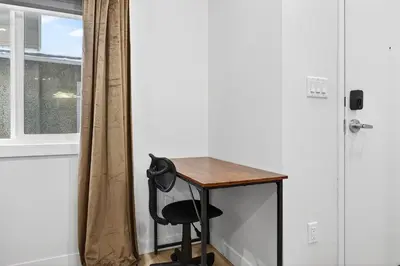 a desk with a chair next to a window at Honeyville House Sleeps 8 Pool Table in Edmonton
