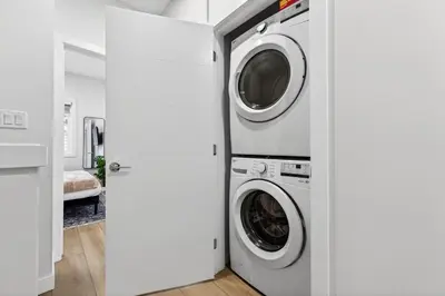 a washer and dryer in a white laundry room at Honeyville House Sleeps 8 Pool Table in Edmonton