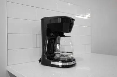 a black coffee maker sitting on top of a counter at Honeyville House Sleeps 8 Pool Table in Edmonton