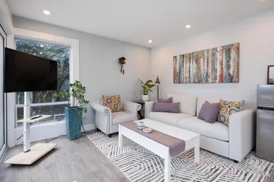 a living room with a couch and a tv at Luxury Modern 2-Bedroom Suite Near Transit & Shops in White Rock