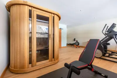 a room with a gym with a mirror and a treadmill at Elk River Estate by Fernie Central Reservations in Fernie