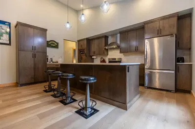 a kitchen with wooden cabinets and a stainless steel refrigerator at Moose Lodge by Fernie Central Reservations in Fernie