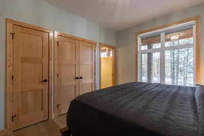 a bedroom with a bed and a window at Moose Lodge by Fernie Central Reservations in Fernie