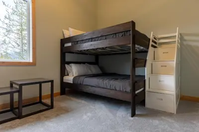 a bedroom with a bunk bed and a desk at Moose Lodge by Fernie Central Reservations in Fernie