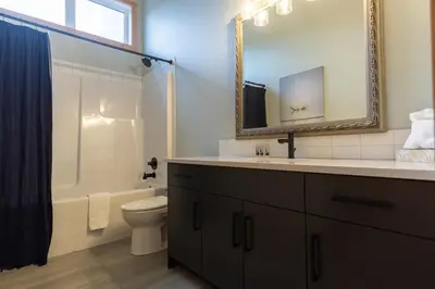 a bathroom with a sink and a toilet and a mirror at Moose Lodge by Fernie Central Reservations in Fernie