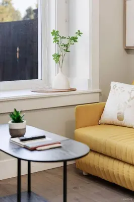 a living room with a yellow couch and a table at Private Entrance Suite Near Deer Lake & Metro in Burnaby