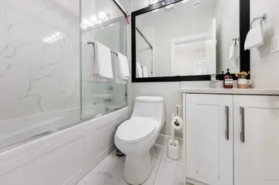 a white bathroom with a toilet and a shower at Private Entrance Suite Near Deer Lake & Metro in Burnaby
