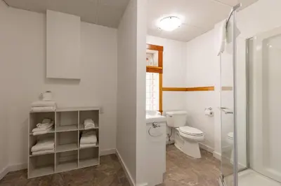 a white bathroom with a toilet and a shower at Huckleberry Lodge by Fernie Central Reservations in Fernie