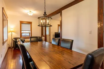 a dining room with a wooden table and leather chairs at Huckleberry Lodge by Fernie Central Reservations in Fernie