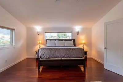 a bedroom with a bed with two lamps and a window at Huckleberry Lodge by Fernie Central Reservations in Fernie