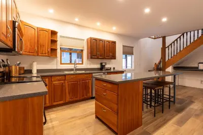 a kitchen with wooden cabinets and a counter top at Huckleberry Lodge by Fernie Central Reservations in Fernie
