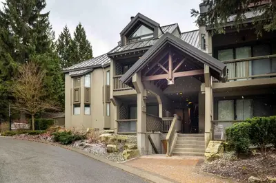 a large house with a gambrel roof at 2BR + Sofabed | Gables | Epic Village Location | Secure Parking | Stylish & Cozy in Whistler
